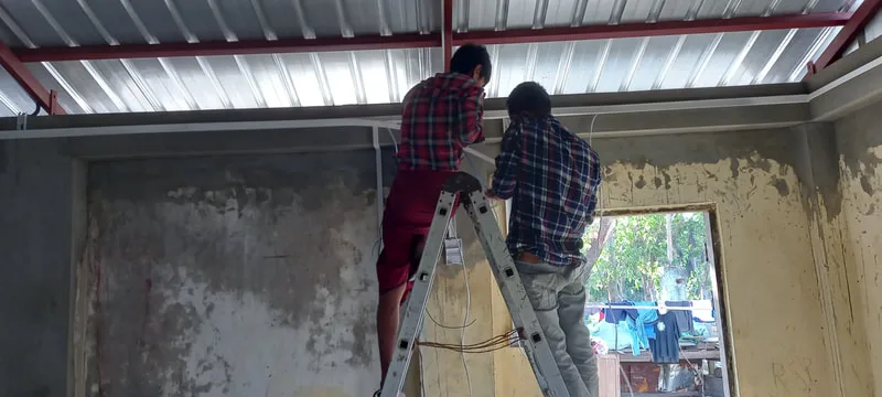 Workers fitting a metal roof support