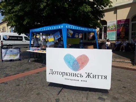 Blue outdoor information stall with a heart logo sign