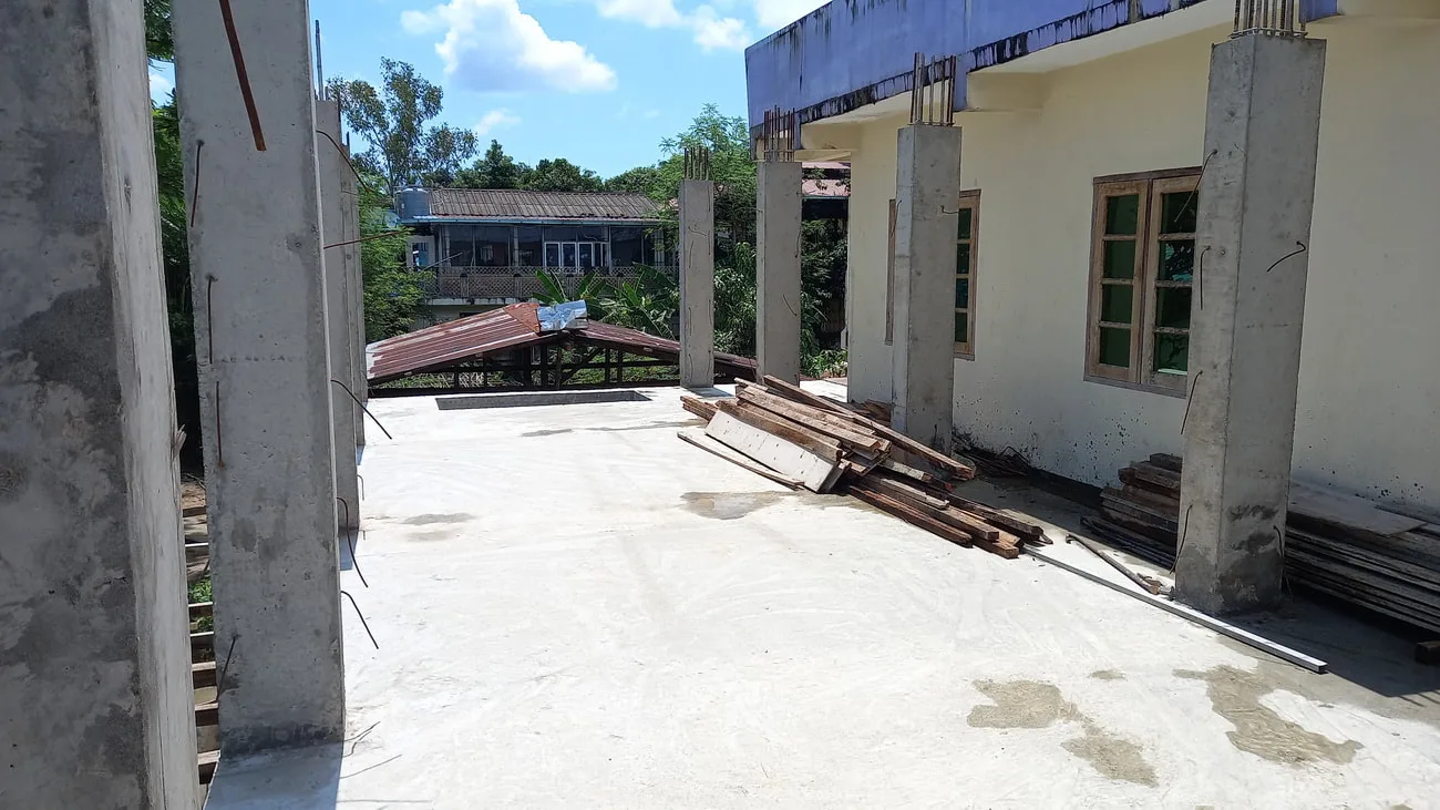 Concrete slab and columns beside an existing building