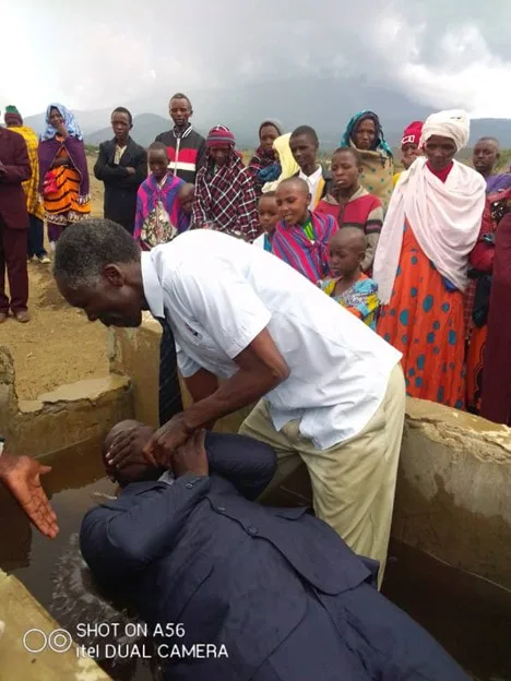 Man being baptized in an outdoor baptismal pool