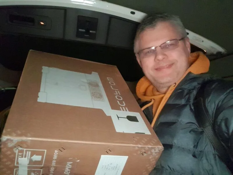 Man holding a box inside a vehicle