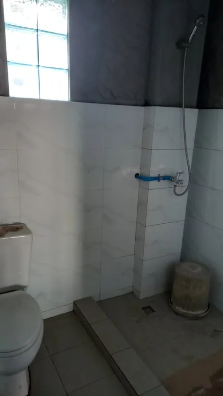 Bathroom with tiled walls and shower fittings