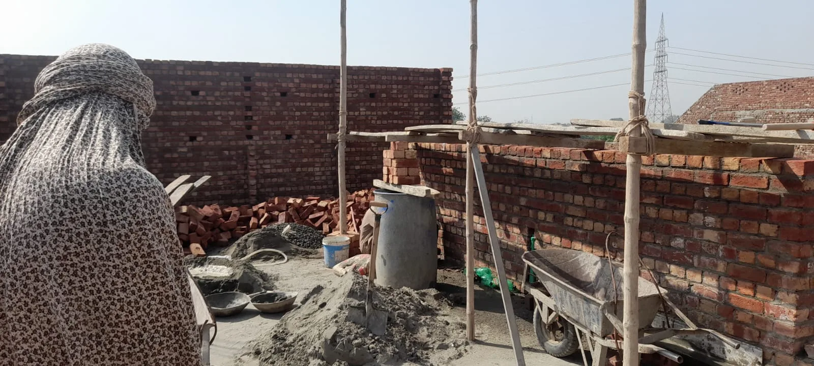 Freshly mixed concrete beside unfinished brick walls