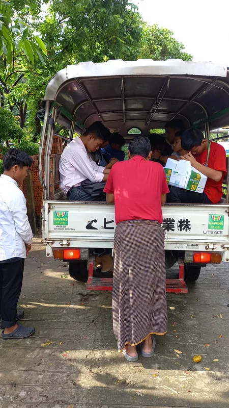 People beside the back of a small truck