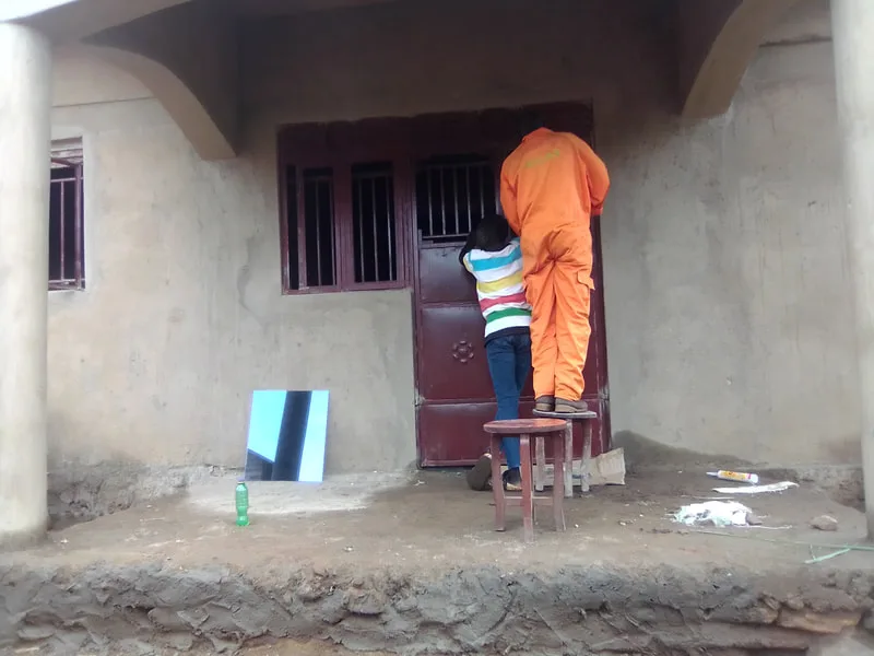 Worker plastering the front wall of a house