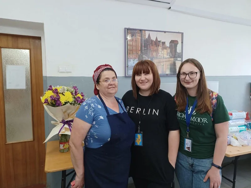Three women standing together indoors