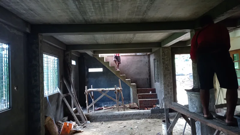 Unfinished interior with workers on scaffolding