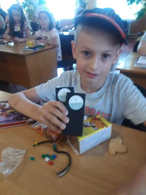 Child holding a key chain and gift box