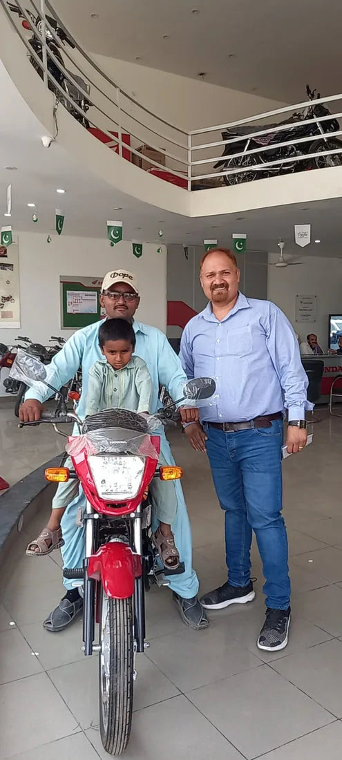 Two men beside a red motorcycle