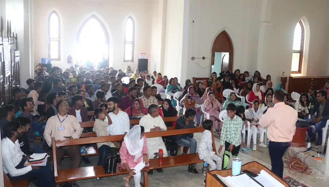Group seated at desks inside a church