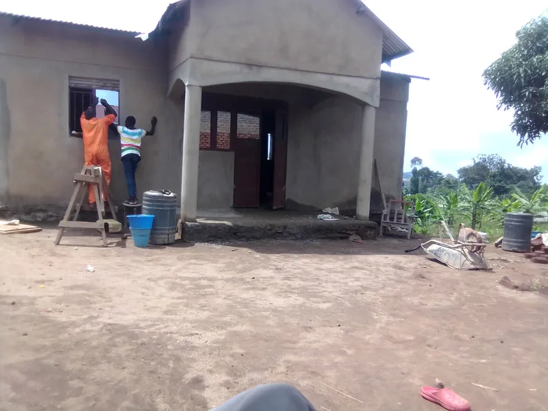 House under construction with workers at the entrance