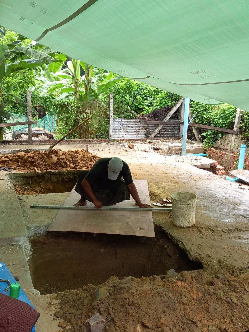 Worker preparing a foundation under a canopy