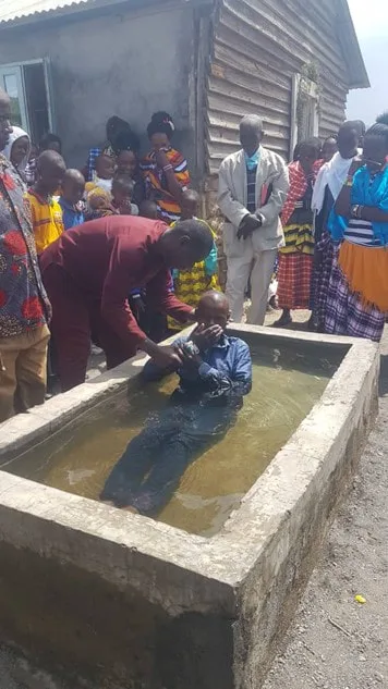 People gathered beside an outdoor baptismal pool
