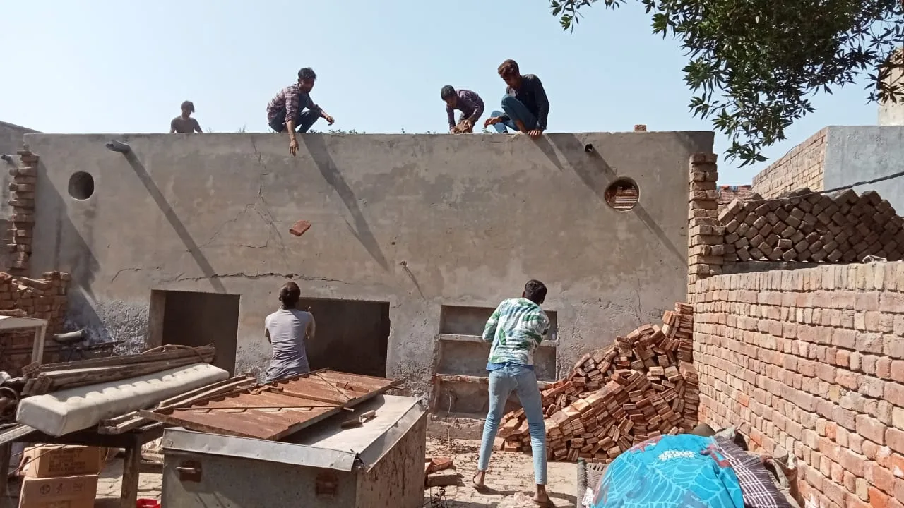 A building under construction with workers on the roof
