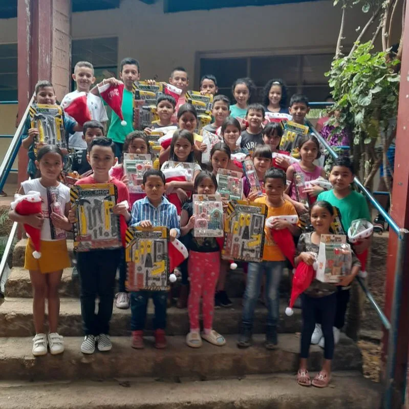 Children holding books on steps outside a building