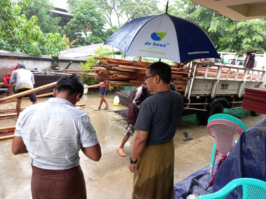 People beside a truck carrying building materials