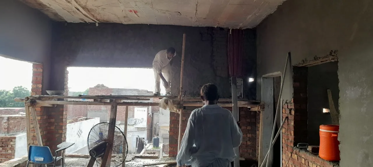 Workers plastering a ceiling and interior walls
