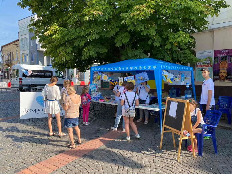 People visiting a blue outdoor stall