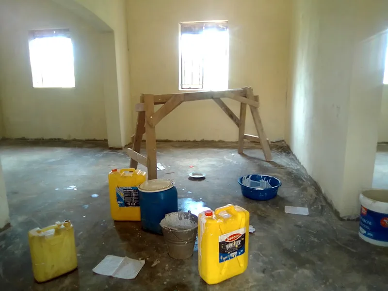 Plastered room with buckets and a workbench
