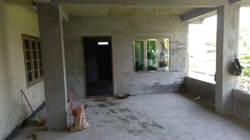 Newly plastered room with doorways and windows