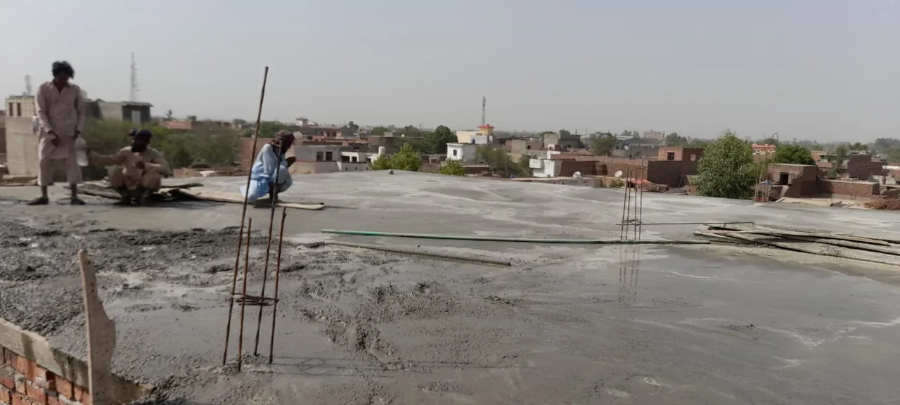 Workers leveling roof concrete