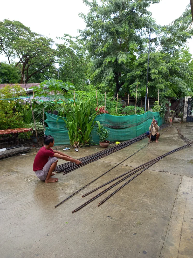 Workers arranging steel reinforcing rods