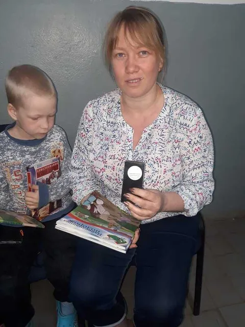 Woman and child holding literature and a key chain