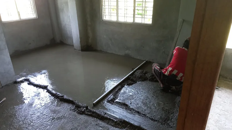 Workers smoothing a fresh concrete floor