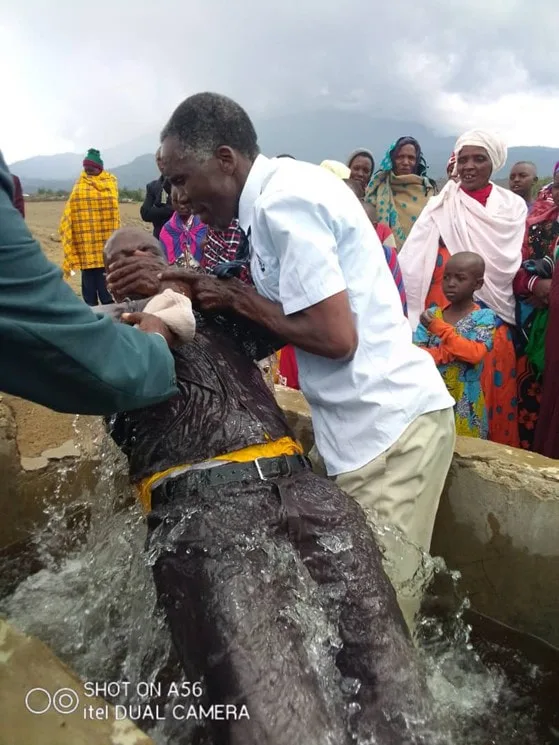 Men assisting at an outdoor baptism