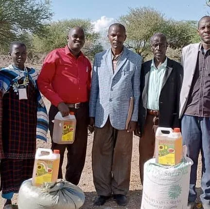 Group standing beside containers and sacks of supplies