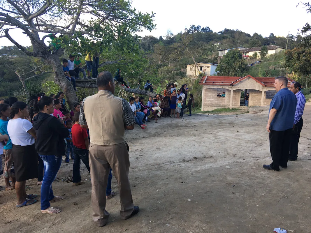 People standing near a hillside house