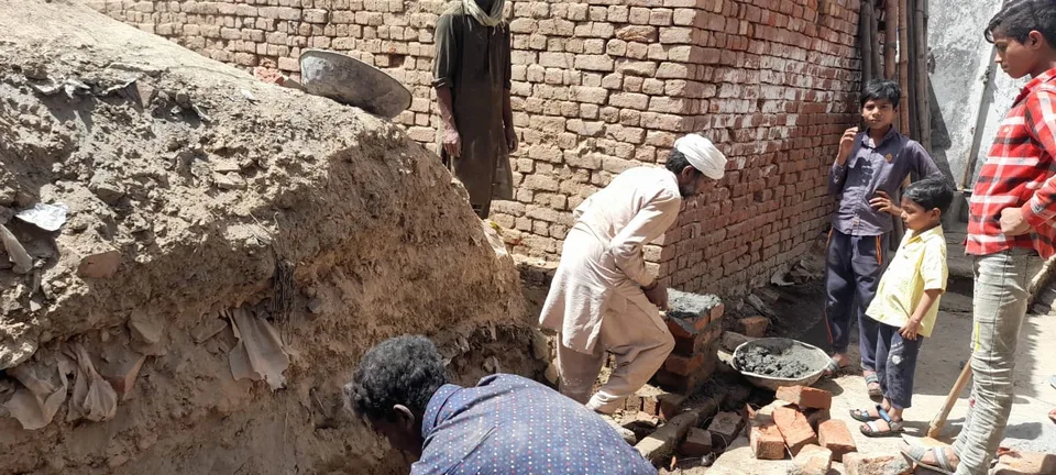 People working at a brick house construction site