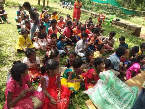 A large group of children and adults gathered outdoors