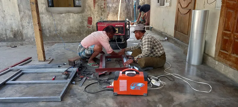 Workers assembling metal frames indoors
