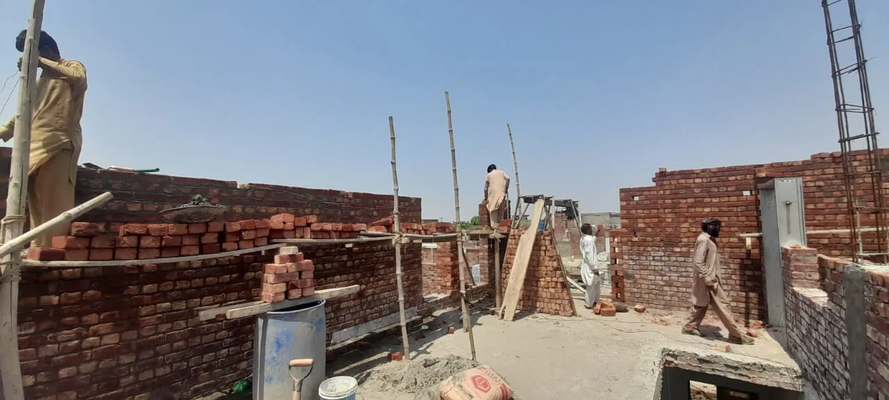 Workers building brick walls at a construction site