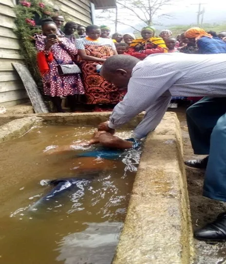 Man assisting a woman in a baptismal pool