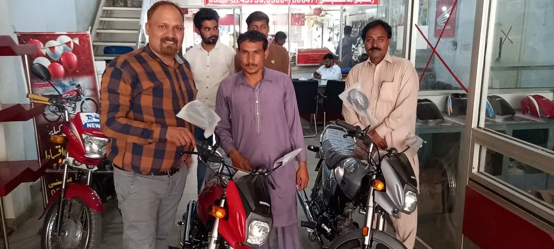 Men standing with newly delivered motorcycles