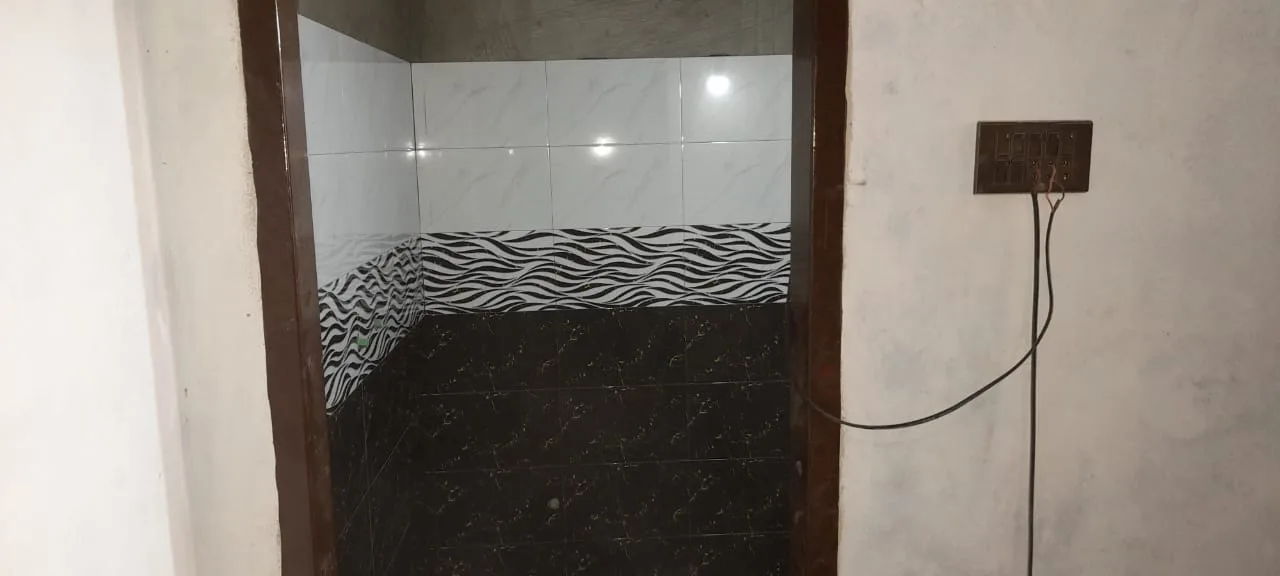 Tiled room with exposed electrical fitting