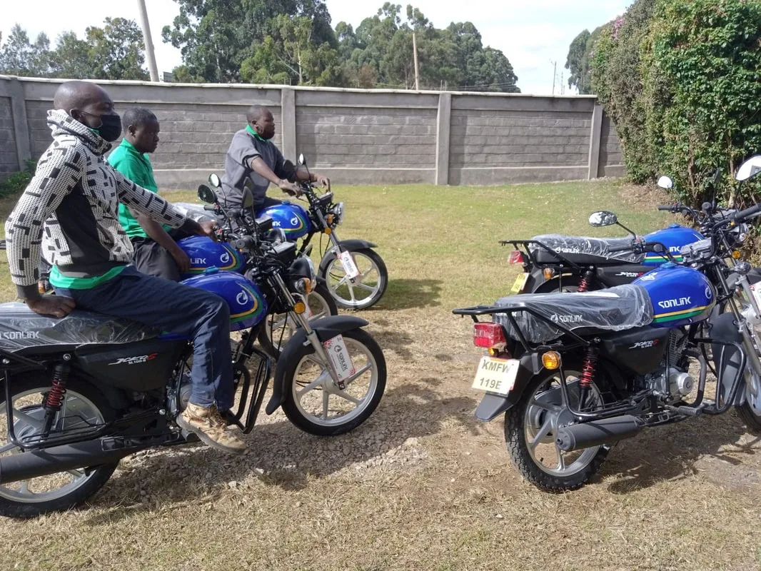 People riding and standing beside motorcycles