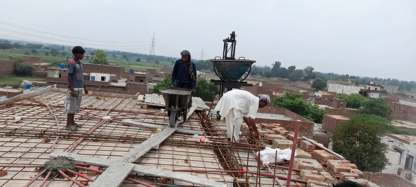 Workers pouring concrete on an upper floor