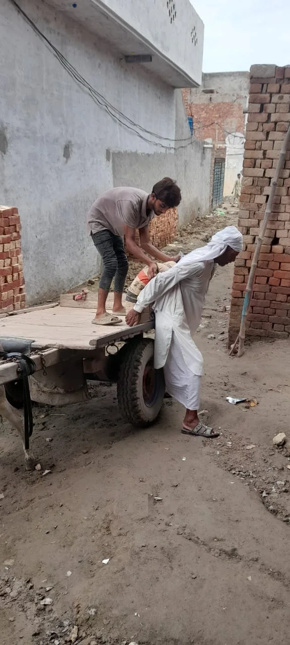 Worker beside a cart of building materials
