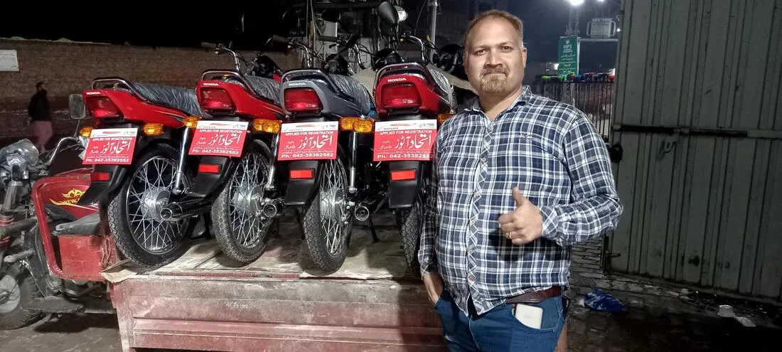 Man beside a row of red motorcycles